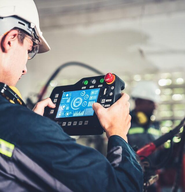 young-factory-worker-working-with-adept-robotic-arm (1)